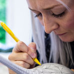 Rhian Malin decorating a mandala bottle in her workshop 2019
